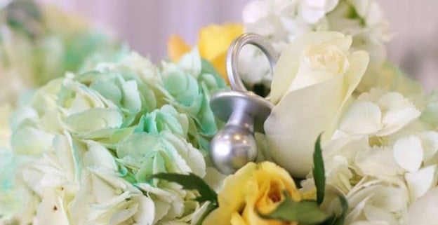 Pacifier decor piece placed in florals at a Glamorous Floral Gender Reveal Party via Kara's Party Ideas | KarasPartyIdeas.com (1)