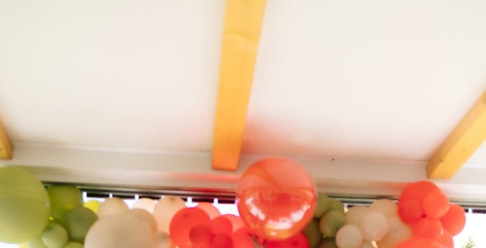 Deconstructed green red and cream balloon garland for a picnic first birthday party