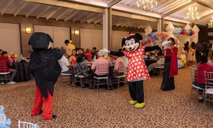 Mickey and Minnie character entertainers greeting guests inside the decorated party venue