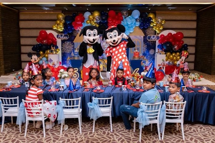Children gathered at the Royal Mickey and Minnie character table during the birthday celebration