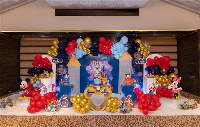 Full Royal Mickey and Minnie birthday party setup with castle backdrop red blue and gold balloons