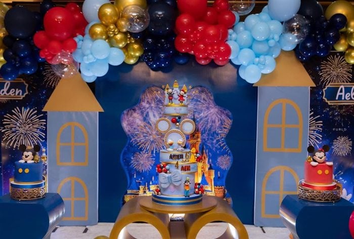 Mickey Mouse cupcake with yellow shoes and blue royal party backdrop