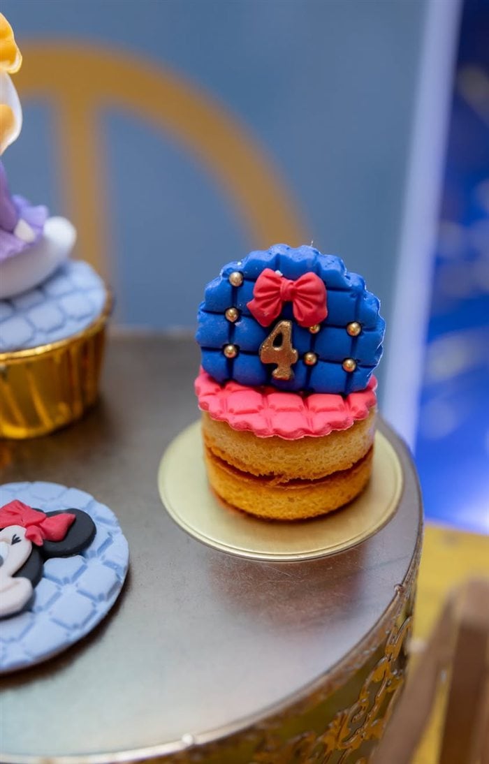 Minnie Mouse cupcake with red bow and blue frosting at the dessert table