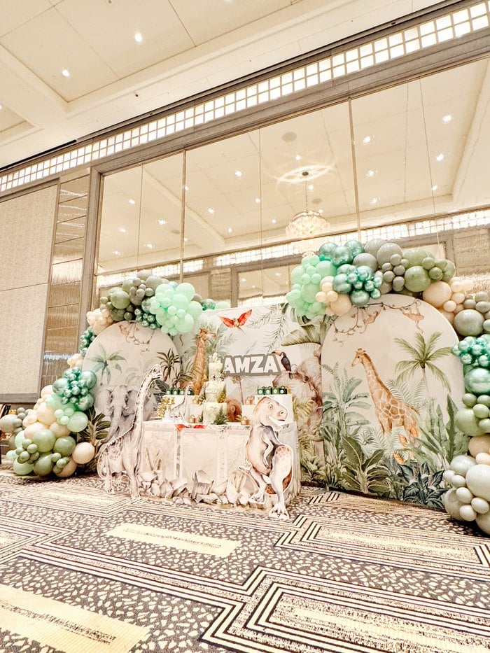 Luxury Jurassic safari party backdrop framed by organic balloons