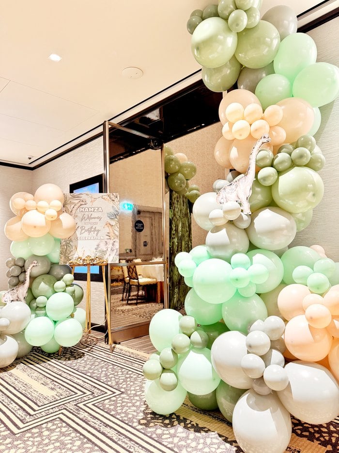 Green ivory and peach organic balloon garland at the party entrance