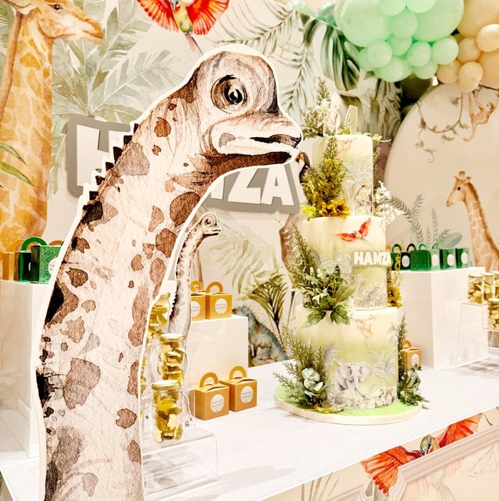 Giraffe beside the personalized Jurassic safari birthday cake display