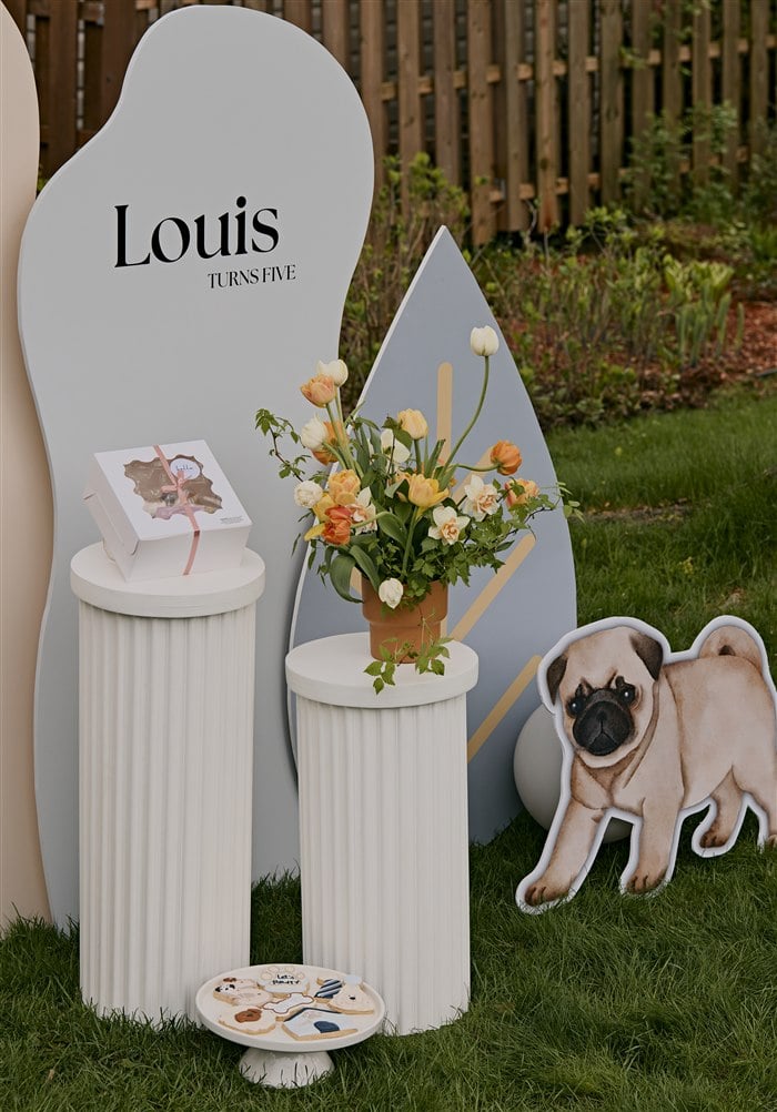 Pug cutout with a white pedestal and floral arrangement