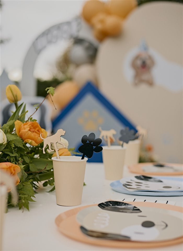 Puppy party table detail with peach flowers dog plates and backdrop