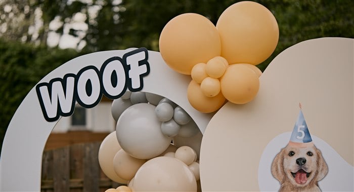 Woof sign with peach cream and gray balloons