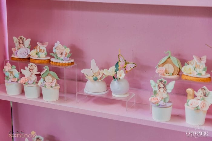 Fairy cupcakes displayed on a pink party shelf