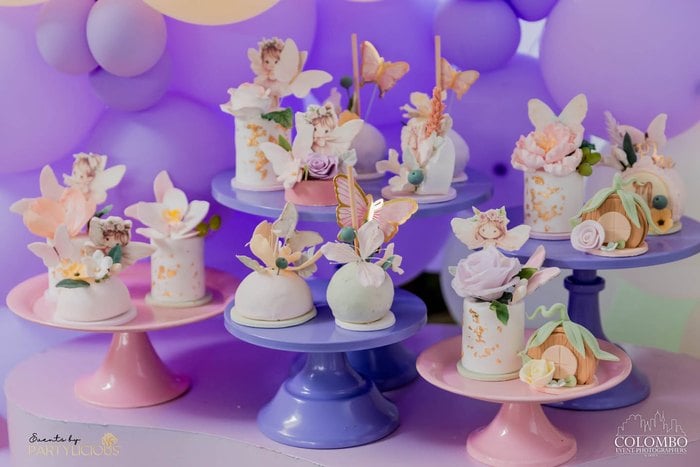 Pastel fairy dessert table with colorful cake stands