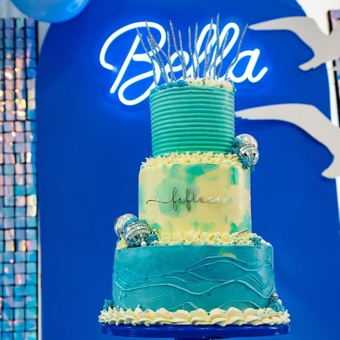 Blue Taylor Swift 1989 birthday cake displayed beneath a personalized Bella sign