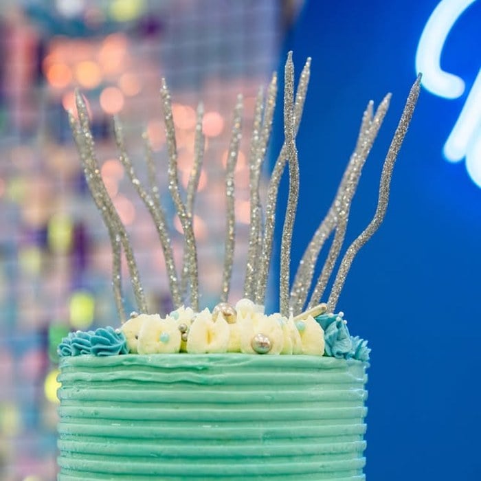 Silver cake topper detail on a blue Taylor Swift 1989 birthday cake